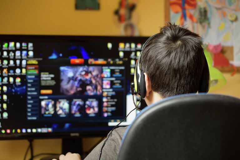 Подросток играет за компьютером