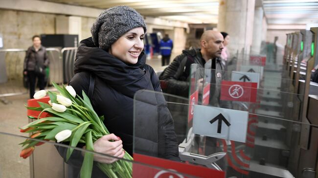 Девушка проходит через турникет в метрополитене