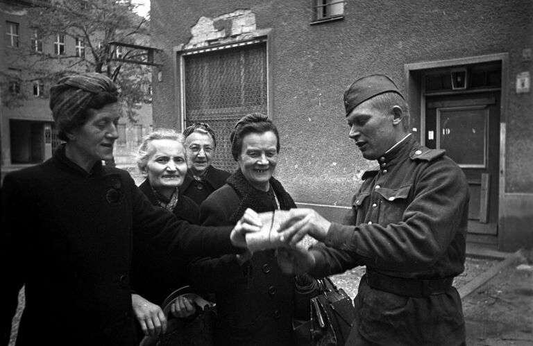 Советский солдат раздает хлеб женщинам Берлина