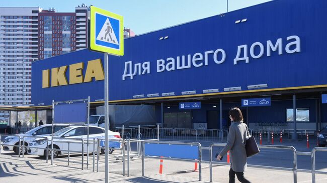 Женщина идет мимо магазина IKEA