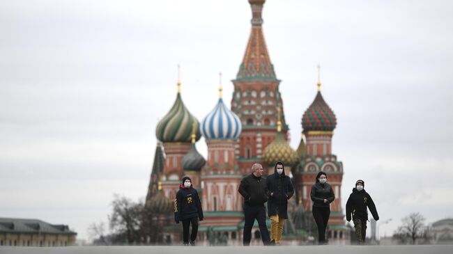 Прохожие в масках на Красной площади в Москве