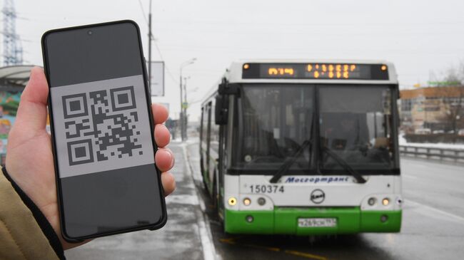 Человек держит смартфон с изображением QR-кода