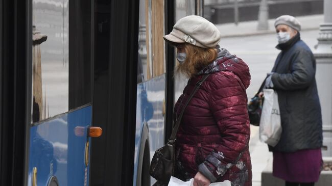 Женщины в медицинских масках у городского автобуса в Москве