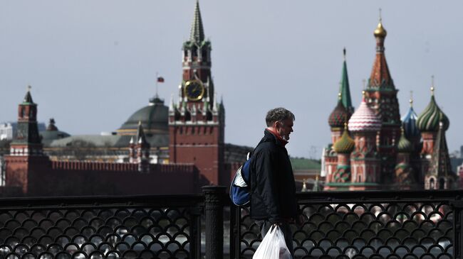 Прохожий с защитной маской на большом Устьинском мосту в Москве