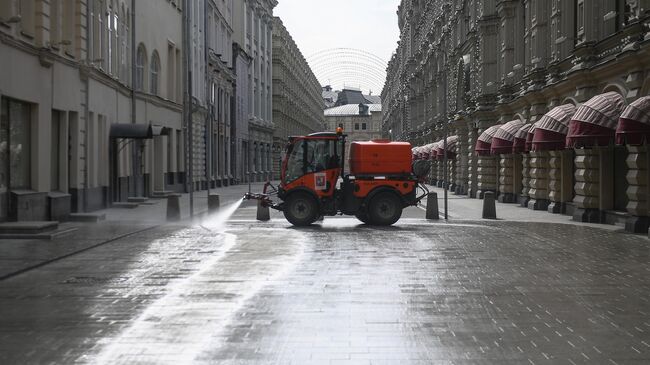 Автомобиль коммунальных служб дезинфицирует дороги и тротуары в центре Москвы