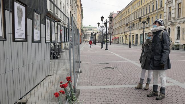 Прохожие у стены памяти умершим от коронавируса медикам в Санкт-Петербурге