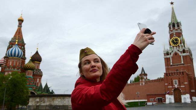 Женщина делает селфи на Красной площади в Москве во время празднования Дня Победы