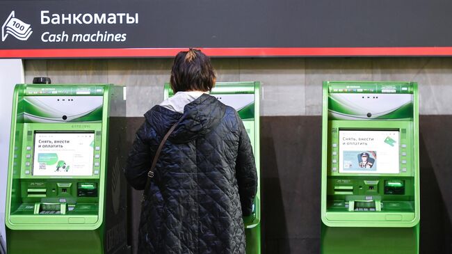 Женщина возле банкоматов на улице Москвы Женщина возле банкоматов на улице Москвы