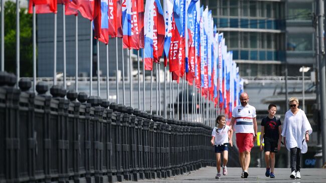 Горожане на Новоарбатском мосту в Москве, украшенном ко Дню России