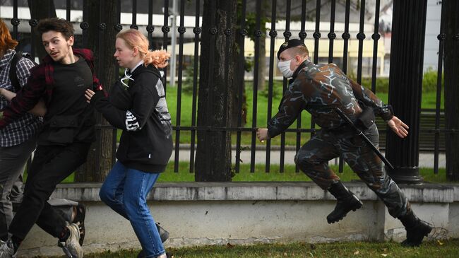 Сотрудник правоохранительных органов и участники акции протеста в Минске