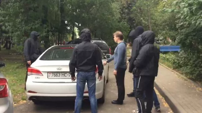 Белорусский оппозиционер Знак садится в машину в сопровождении неизвестных 