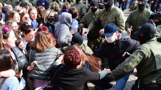 Участницы женского марша Подруга за подругу и сотрудники правоохранительных органов на площади Свободы в Минске