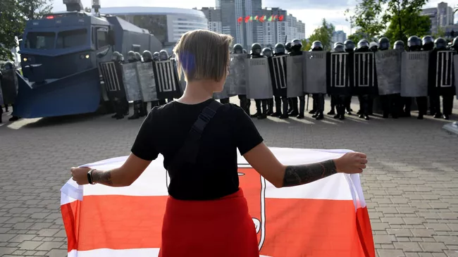 Участница несанкционированной акции оппозиции и сотрудники правоохранительных органов в Минске