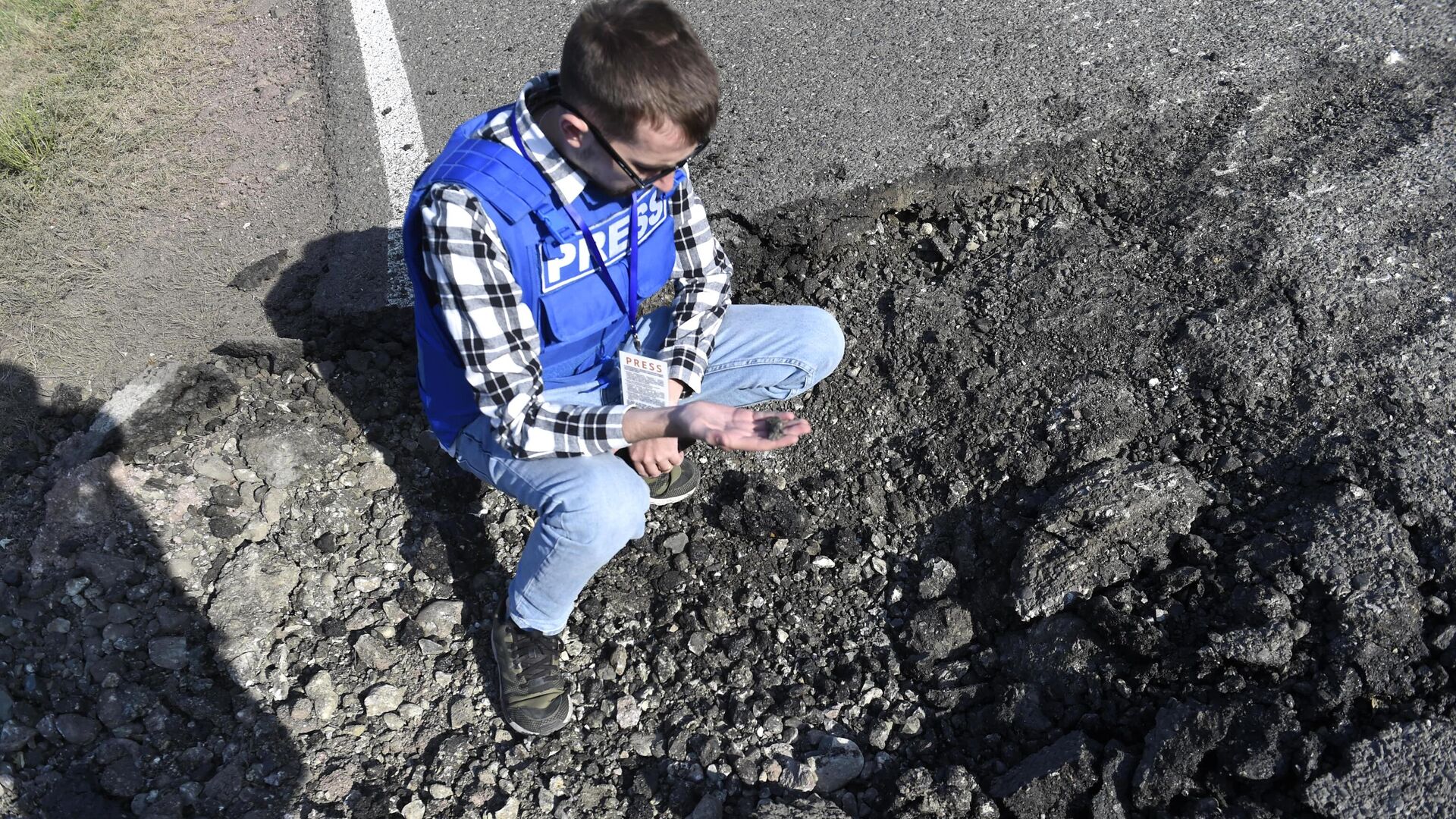 Журналист держит в руках осколок от снаряда в Мартакертском районе Нагорного Карабаха - РИА Новости, 1920, 01.10.2020