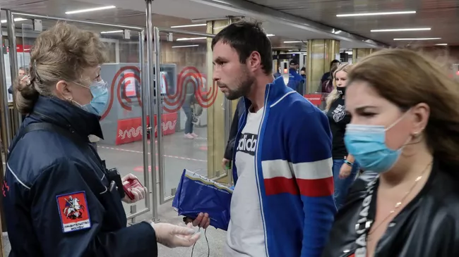 Пассажиры в вестибюле станции метро Пражская в Москве, где проводится проверка масочного режима
