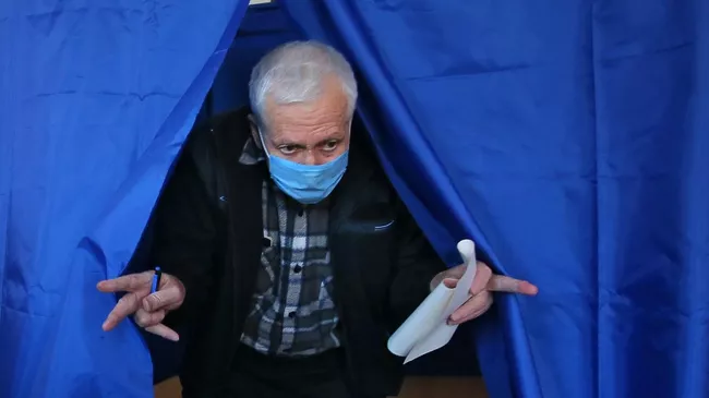 Мужчина голосует на одном из избирательных участков в Киеве