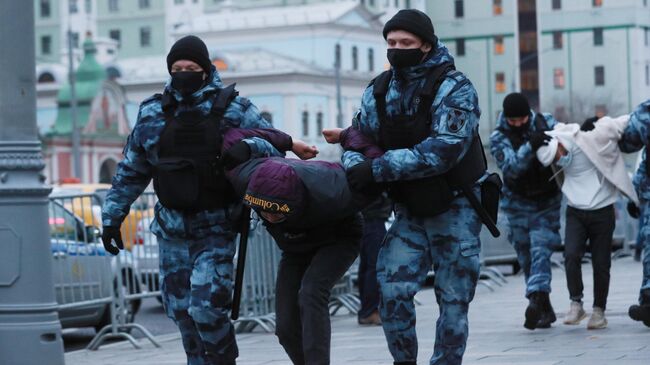 Сотрудники полиции задерживают участника акции протеста около посольства Франции в Москве