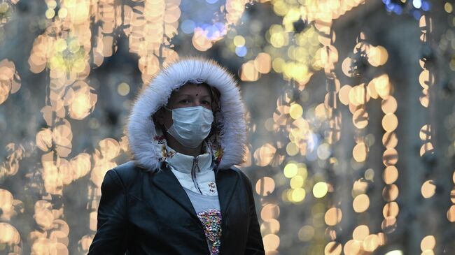 Женщина в защитной маске на улице в Москве