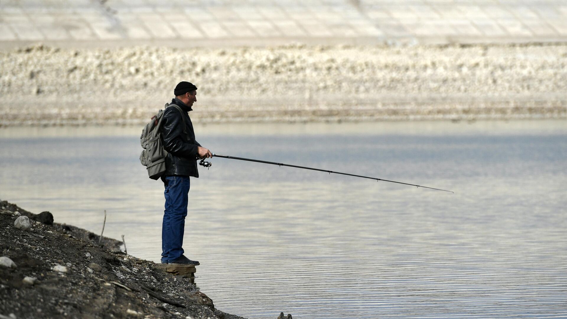 Человек ловит рыбу на берегу Аянского водохранилища в Крыму - РИА Новости, 1920, 25.12.2020