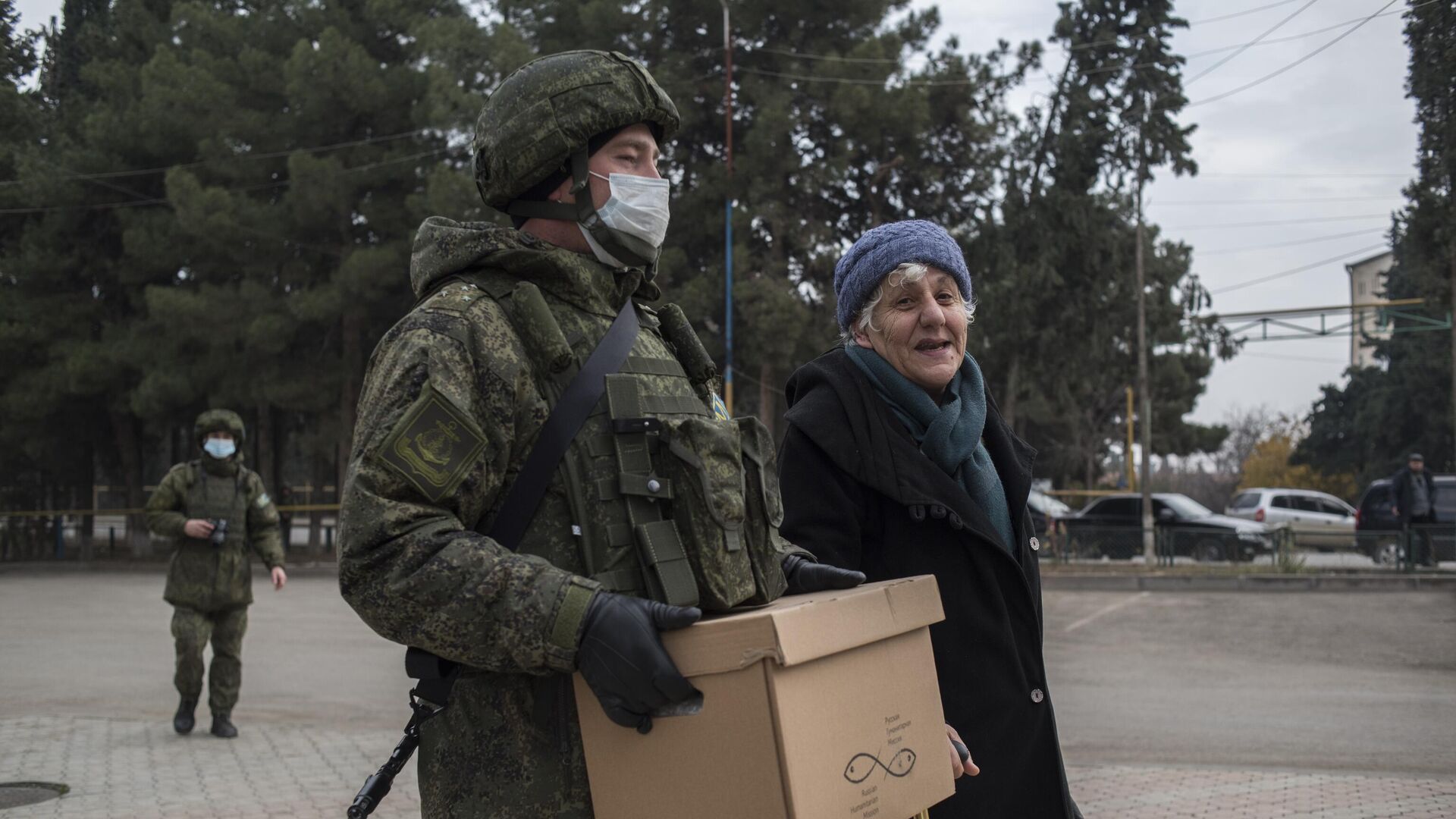 Военнослужащий российского центра по примирению враждующих сторон раздает гуманитарную помощь жителям города Мартакерт в Нагорном Карабахе - РИА Новости, 1920, 24.12.2020