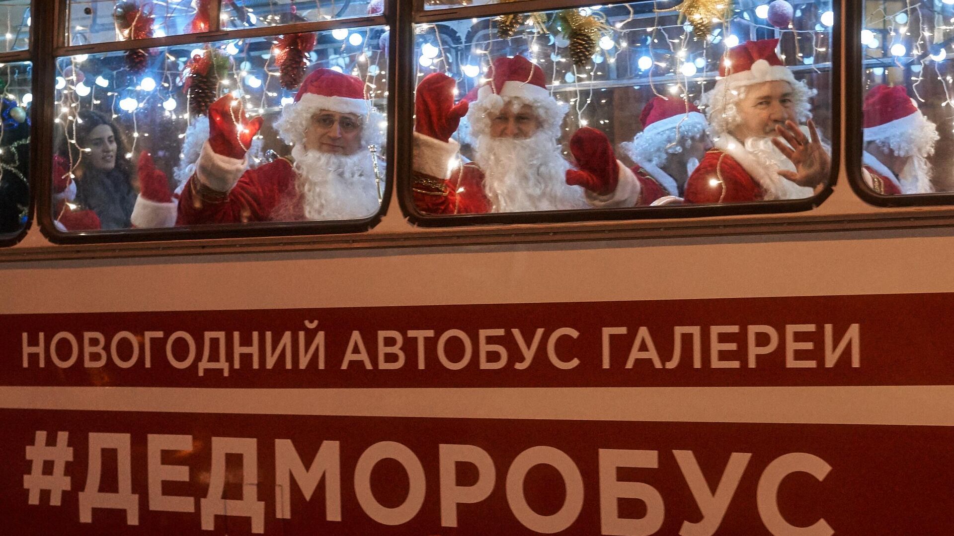 Музыканты в костюмах Дедов Морозов в новогоднем автобусе с оркестром Дедморобусе на Невском проспекте в Санкт-Петербурге - РИА Новости, 1920, 25.12.2021