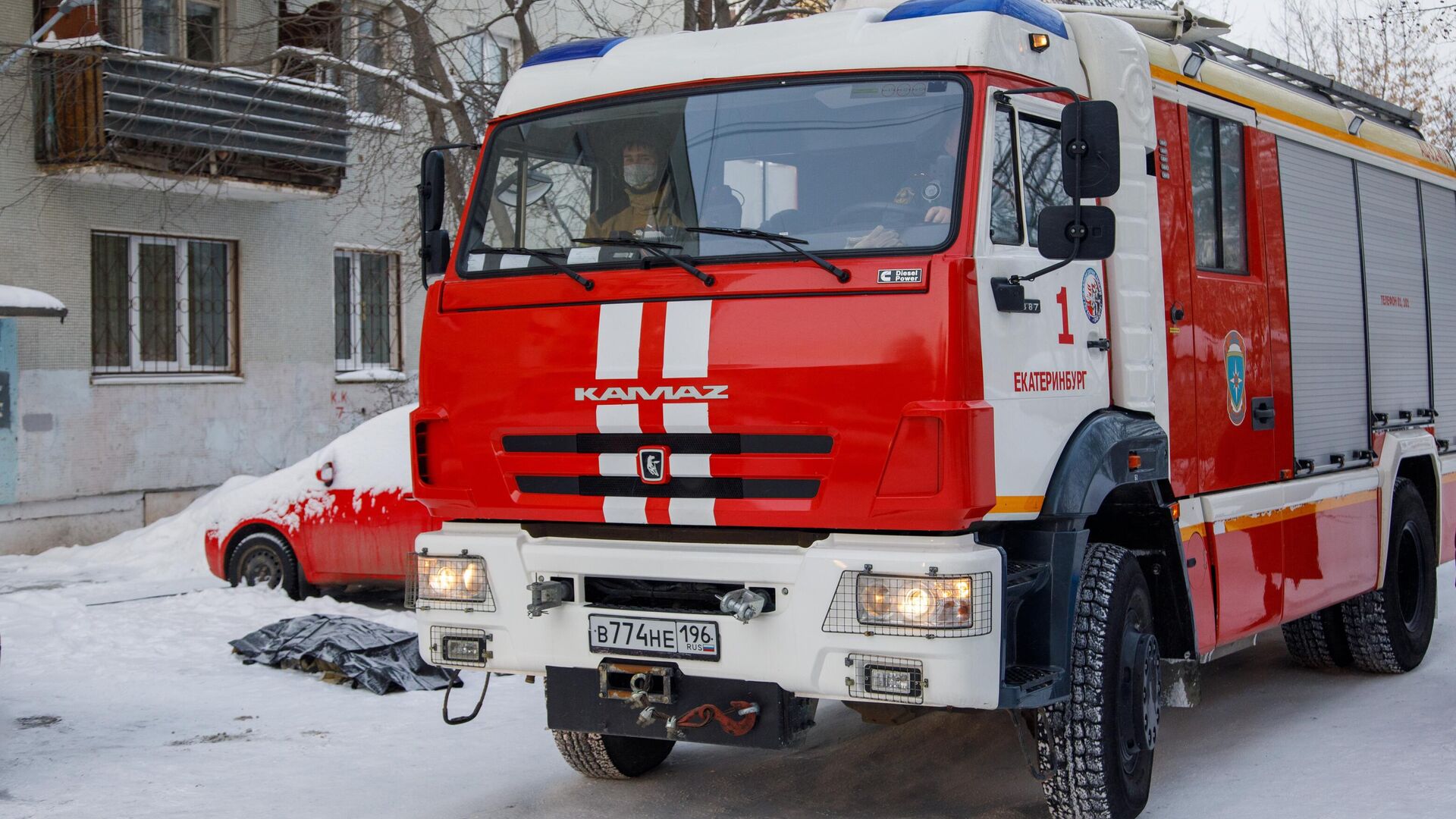 Автомобиль пожарной службы по дворе жилого дома на улице Рассветной в Екатеринбурге, где произошел пожар - РИА Новости, 1920, 01.02.2021