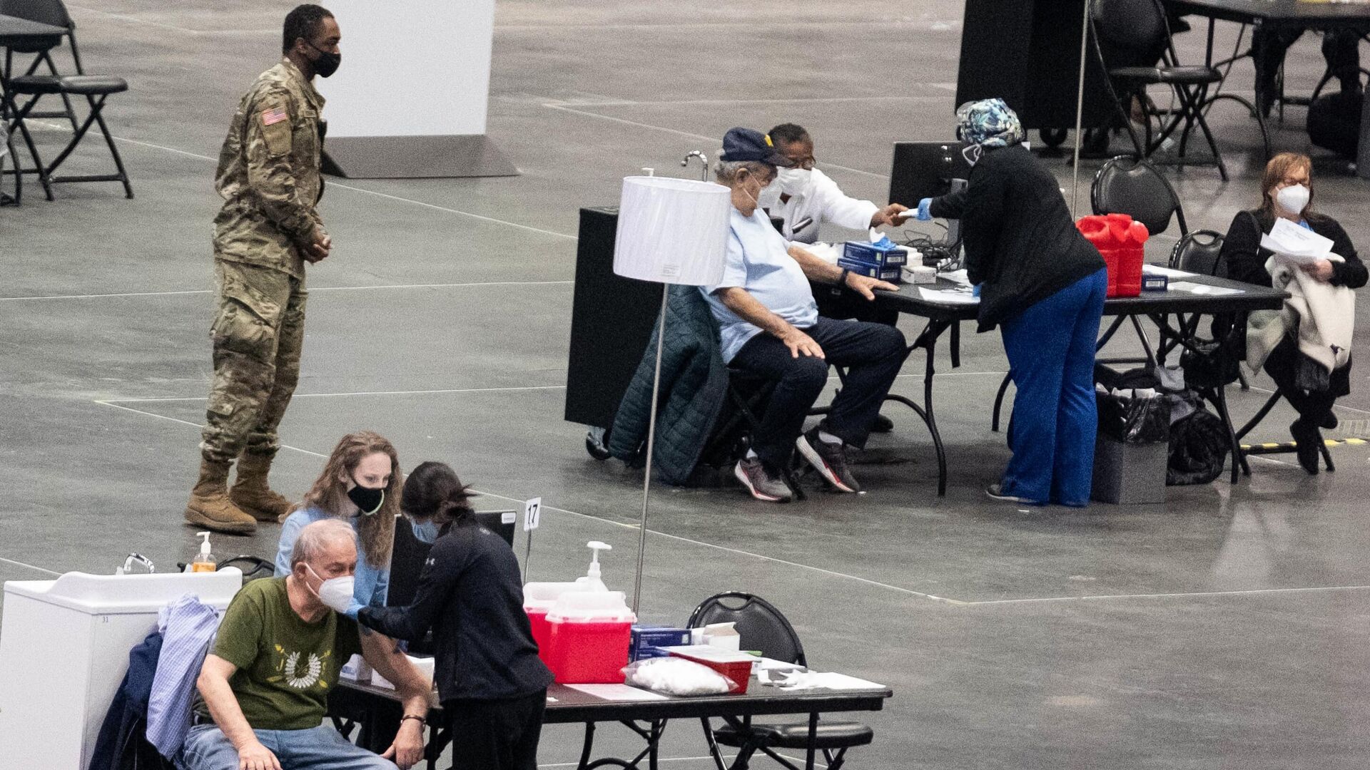 Сотрудники и посетители в центре вакцинации от коронавируса на территории конференц-центра Якоба Явица в Нью-Йорке - РИА Новости, 1920, 21.03.2021