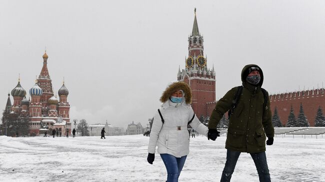 Прохожие на заснеженной Красной площади в Москве