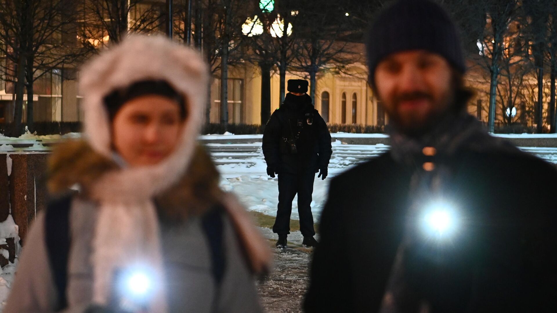 Сотрудник полиции наблюдает за порядком во время флешмоба с включенными фонариками в Москве - РИА Новости, 1920, 15.02.2021