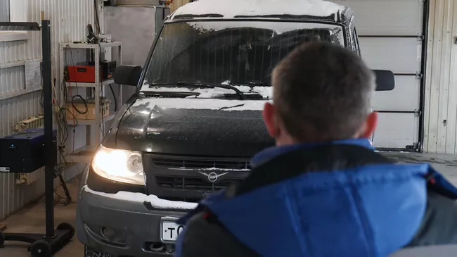 Технический эксперт проводит осмотр автомобиля на пункте технического осмотра 