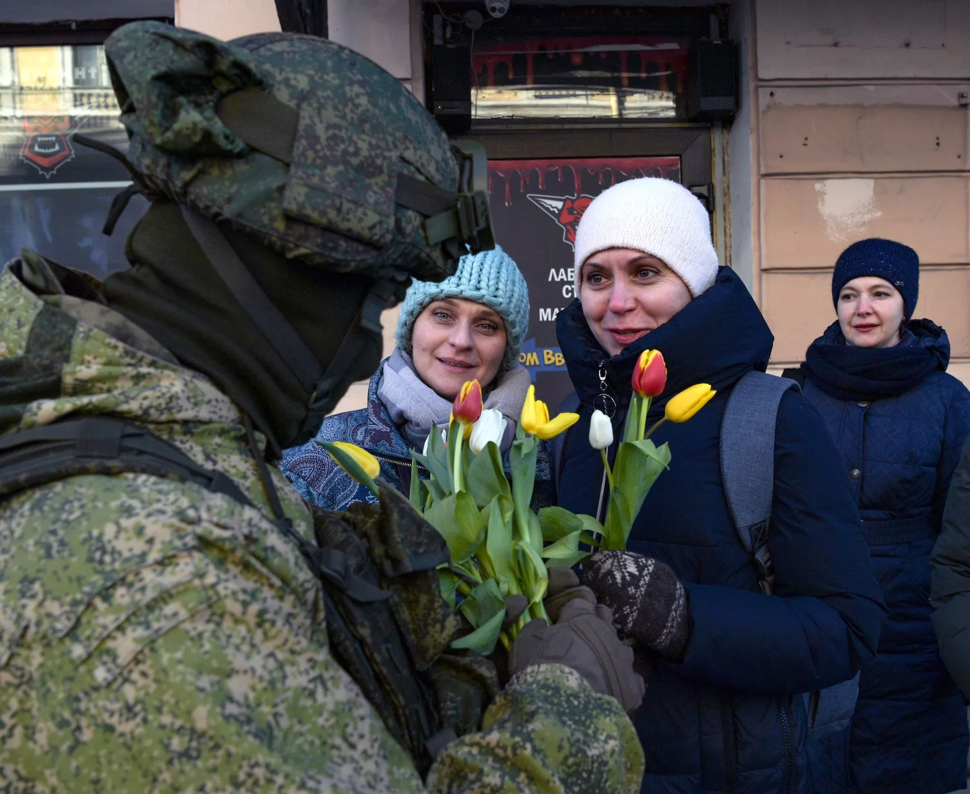 Военнослужащий поздравляет женщин с наступающим Международным женским днем на Дворцовой площади в Санкт-Петербурге - РИА Новости, 1920, 22.02.2022