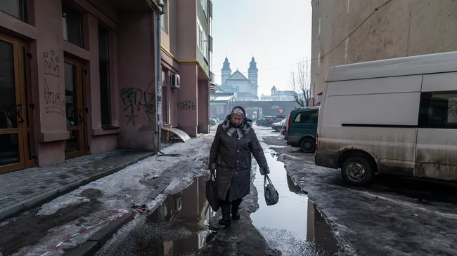 Женщина идет по улице в Ивано-Франковске, Украина 