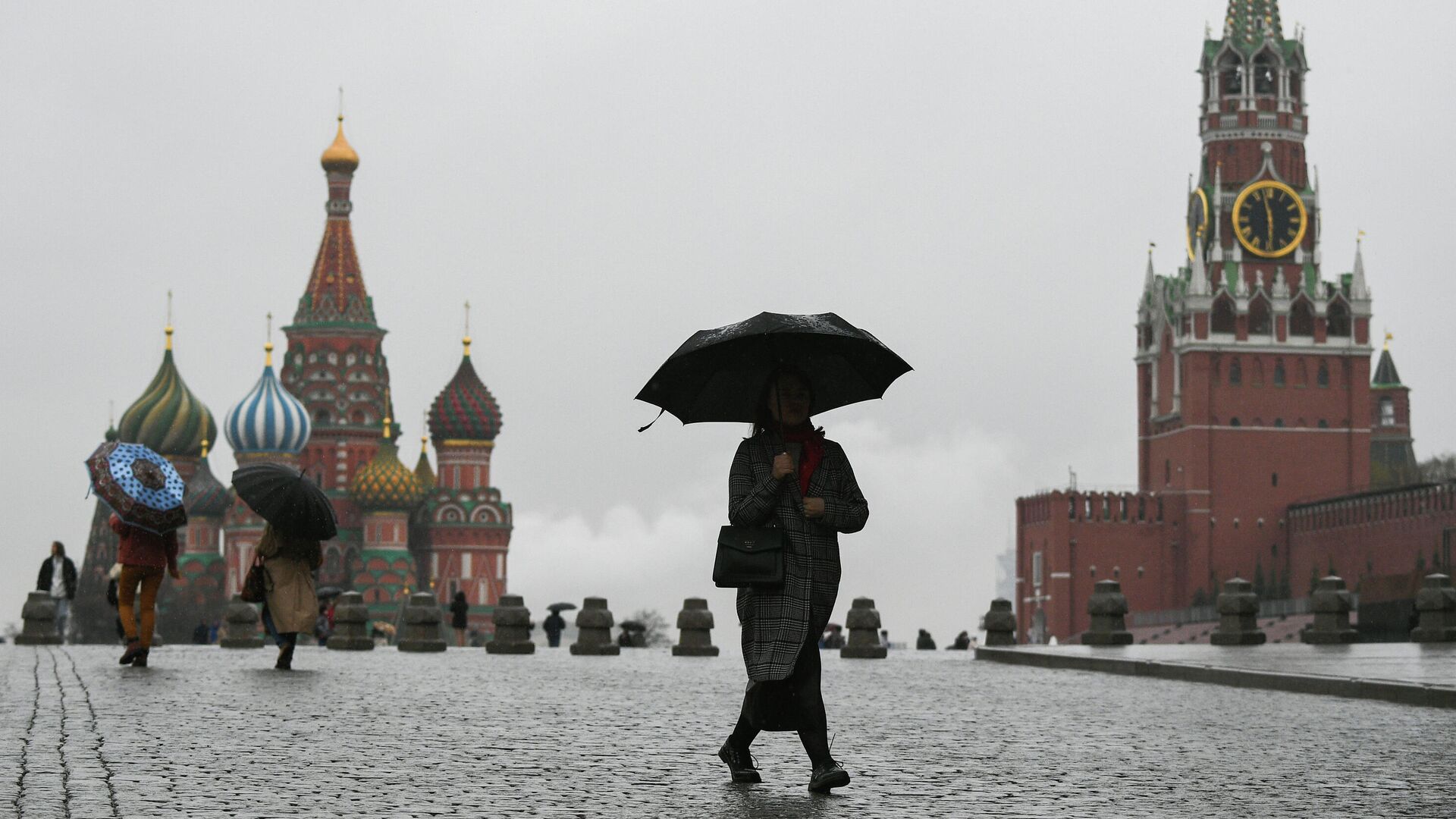 Люди во время дождя на Красной площади в Москве. Архивное фото - РИА Новости, 1920, 06.05.2024