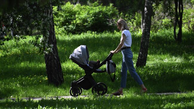 Женщина с ребенком на прогулке в сквере