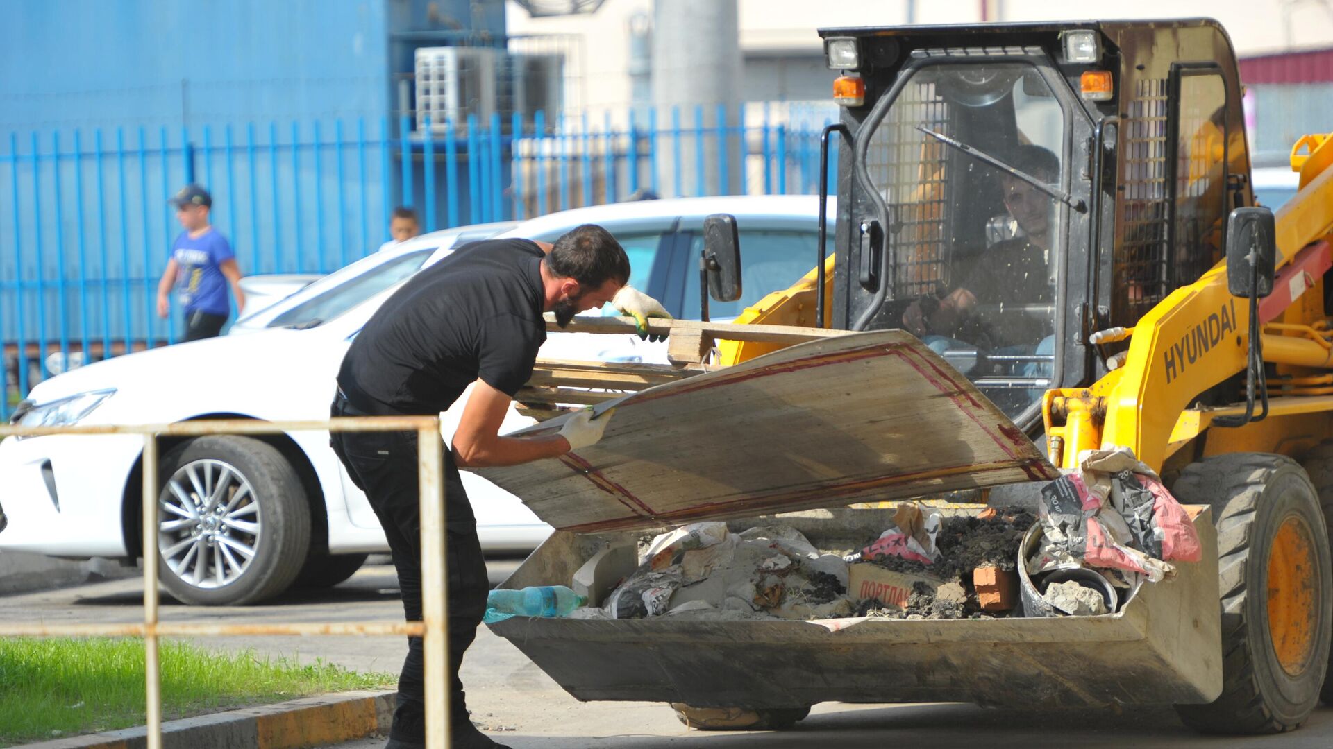 Рабочий загружает в погрузчик строительный мусор - РИА Новости, 1920, 07.06.2022