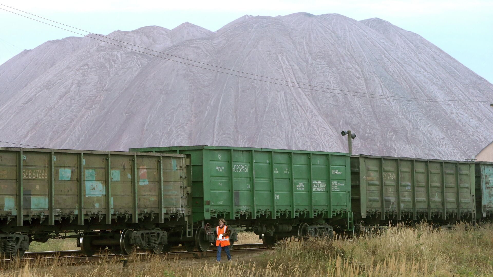 Женщина считает вагоны около отвалов отработанной породы из шахты рудника на проходческом комплексе производителя калийных минеральных удобрений ОАО Беларуськалий в городе Солигорск - РИА Новости, 1920, 25.12.2021