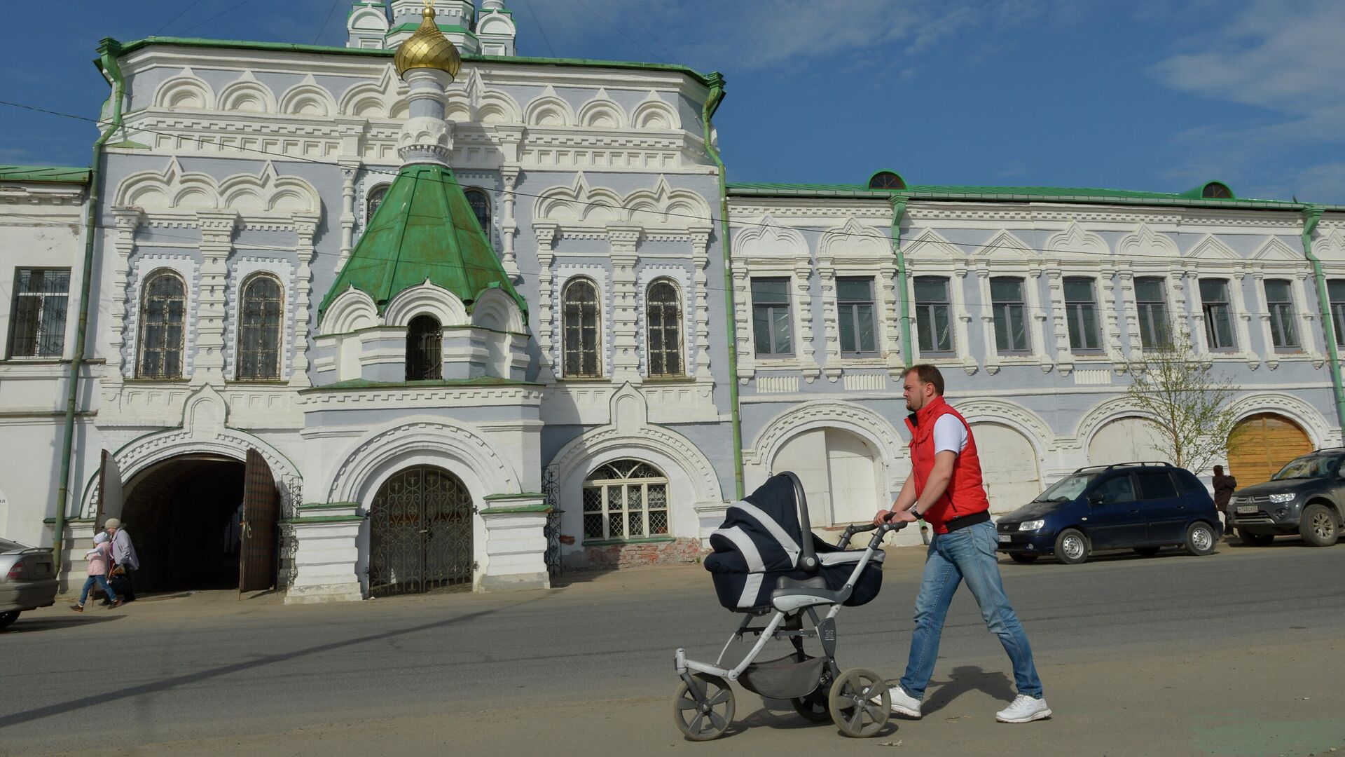 Мужчина с детской коляской идет по набережной Северной Двины у Архангельского подворья Спасо-Преображенского Соловецкого монастыря - РИА Новости, 1920, 14.09.2021