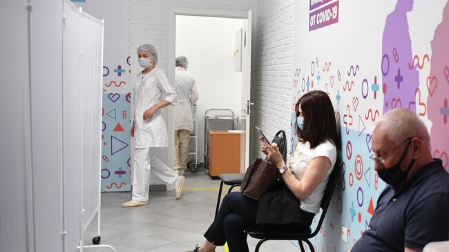 Люди в очереди на вакцинацию российским препаратом Спутник V (Гам-КОВИД-Вак) от COVID-19 в торговом центре Арена Плаза в Москве