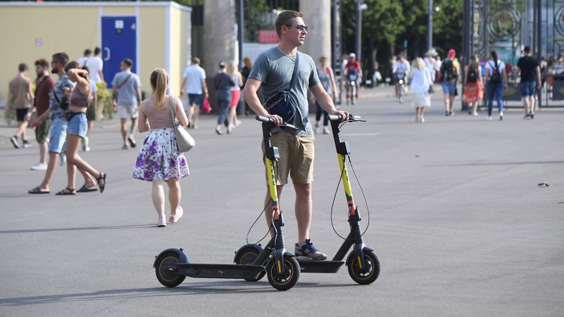 Молодой человек с электросамокатами у входа в ЦПКиО имени Горького в Москве - РИА Новости, 1920, 29.07.2021