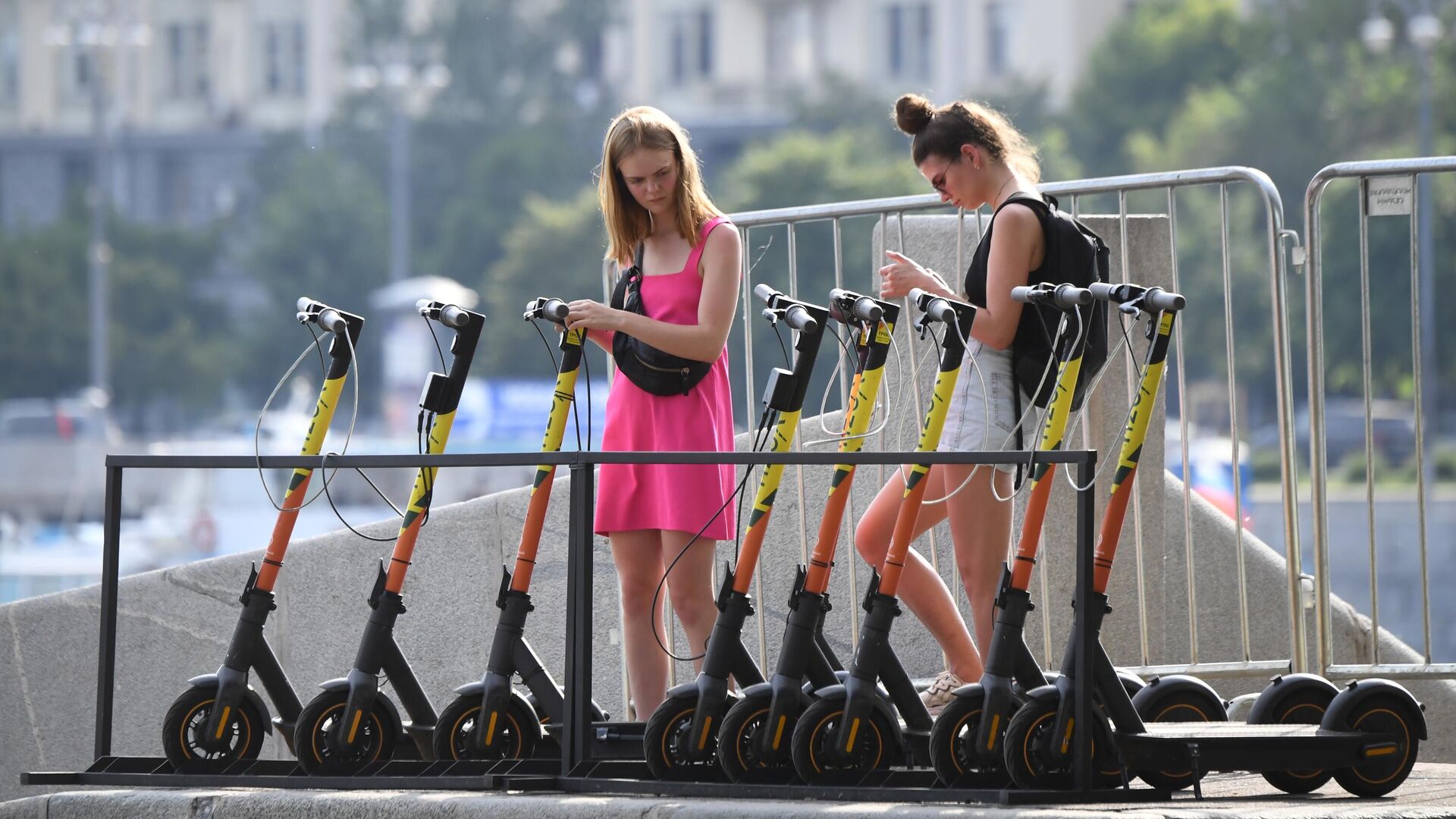 Девушки берут на прокат электросамокаты на набережной Москвы-реки в ЦПКиО имени Горького в Москве - РИА Новости, 1920, 17.07.2025