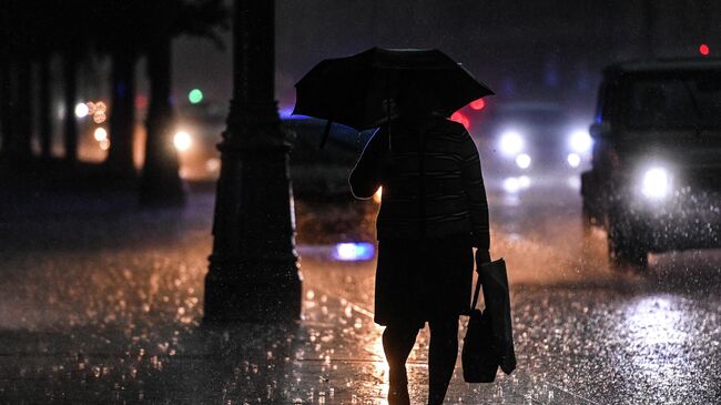 Женщина на одной из улиц в Москве во время дождя