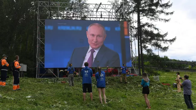Люди смотрят трансляцию прямой линии с президентом РФ Владимиром Путиным в фанпарке Бобровый лог в Красноярске