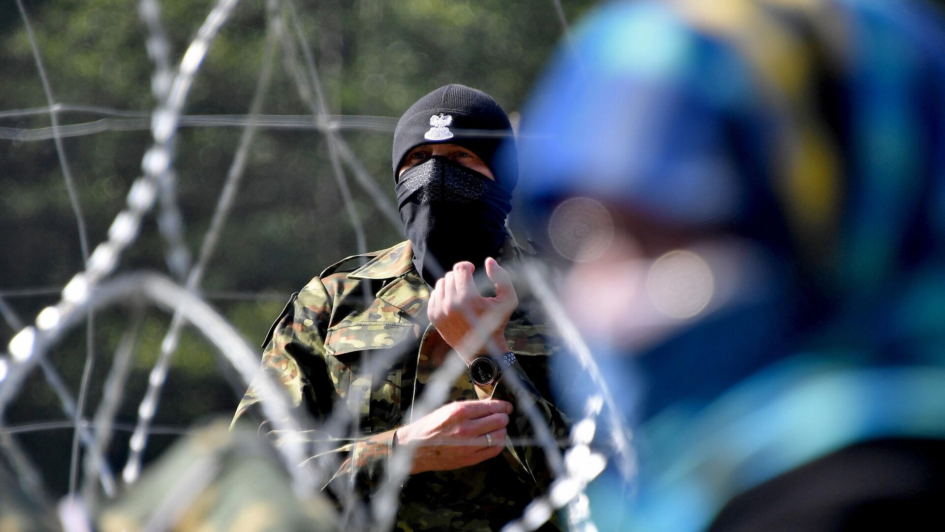 Польский пограничник наблюдает за лагерем беженцев из Афганистана на белорусско-польской границе. - РИА Новости, 1920, 16.10.2021