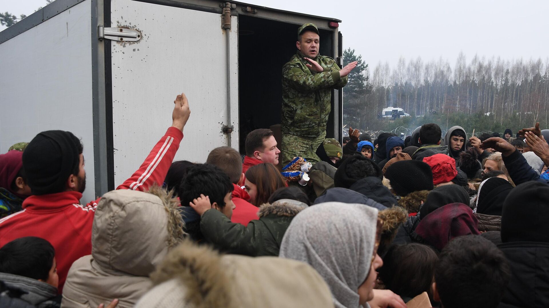 Раздача гуманитарной помощи в лагере нелегальных мигрантов на белорусско-польской границе - РИА Новости, 1920, 12.11.2021