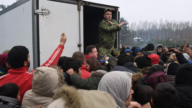 Раздача гуманитарной помощи в лагере нелегальных мигрантов на белорусско-польской границе