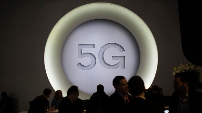 Люди рядом с логотипом 5G во время Mobile World Congress