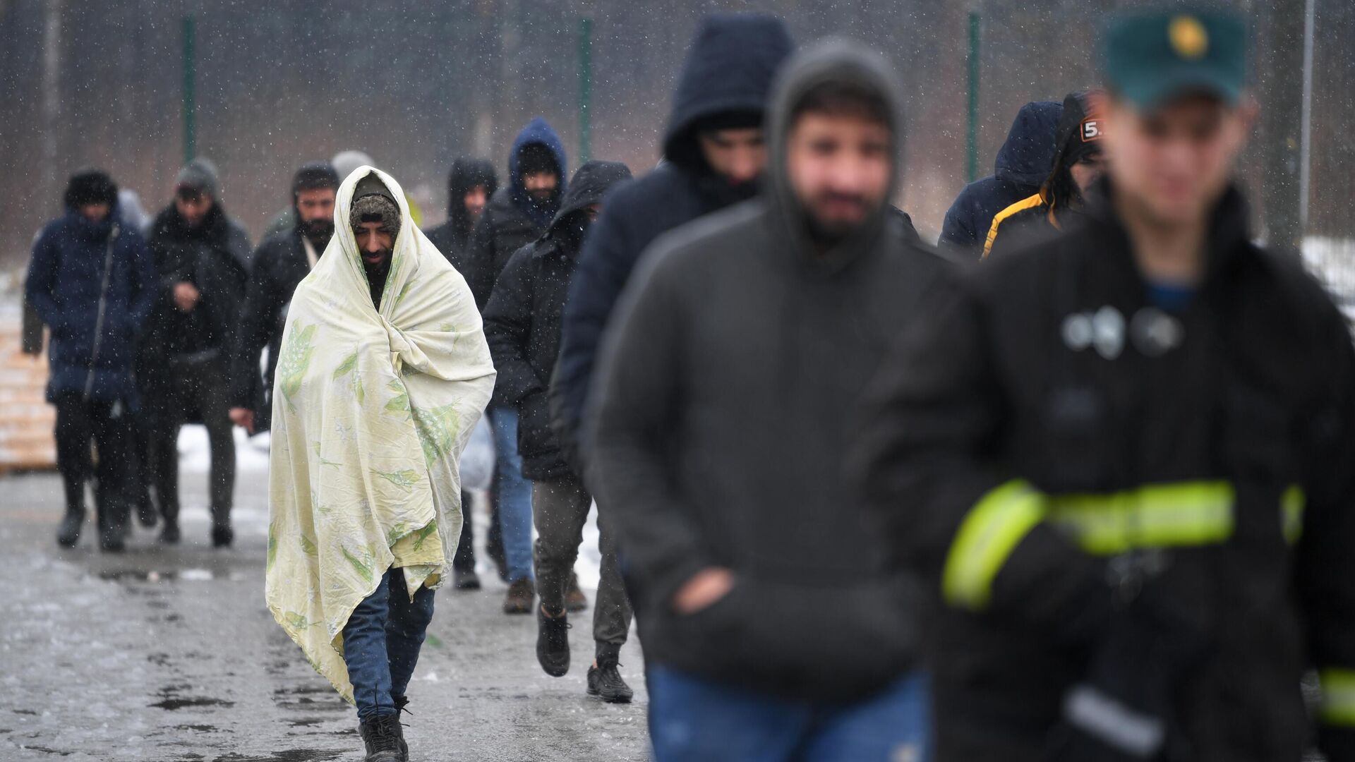 Беженцы с Ближнего Востока идут после купания в полевой бане в лагере мигрантов, оборудованном в логистическом центре в пункте пропуска Брузги на белорусско-польской границе - РИА Новости, 1920, 29.11.2021