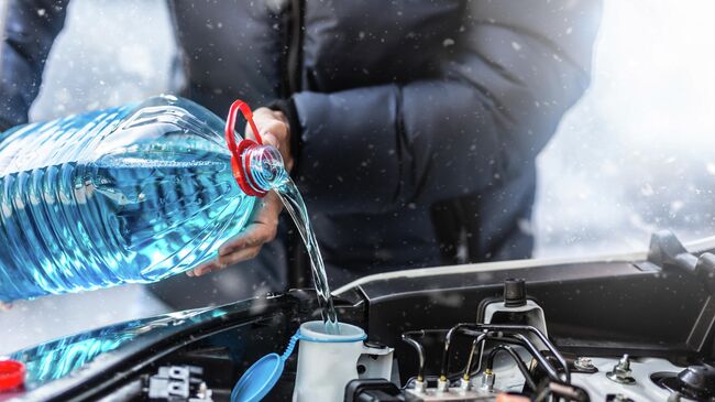 Мужчина заливает антифриз