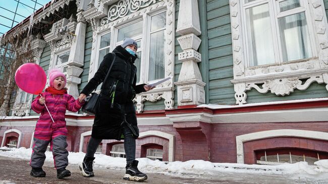 Женщина с ребенком проходят мимо особняка Токаревой в Перми