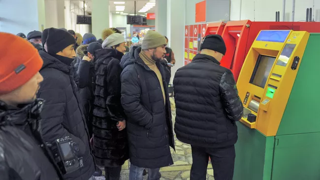 Люди стоят в очереди к банкоматам в Нур-Султане